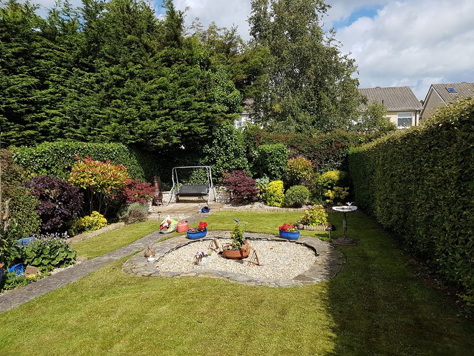 A finished garden with neat lawn, trimmed hedges and planted beds